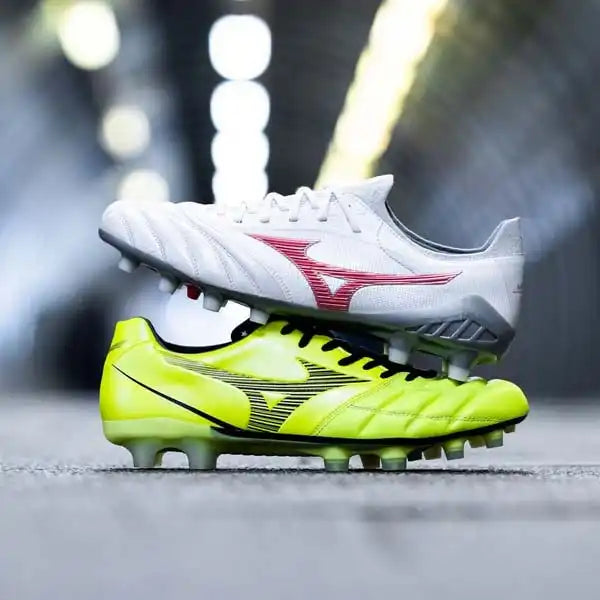 Deux crampons de soccer Mizuno empilés, l'un blanc avec des accents rouges et l'autre jaune néon avec des accents noirs.